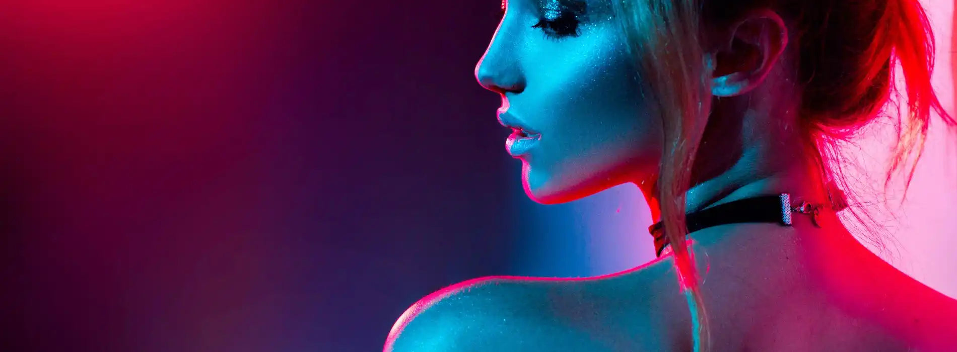 Woman in a sexy costume, wearing a choker, illuminated by dramatic neon pink and blue lighting, looking seductively to the side.